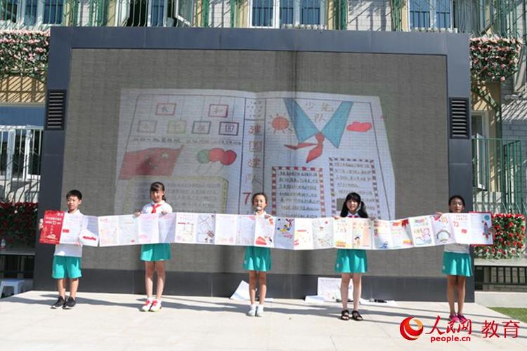 回民小学学生展示假期中制作的制作的喜迎新中国成立70周年的手抄报