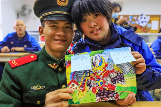 残障儿童写给武警官兵的感恩贺卡后战士露出开心的笑容.曾欣 摄