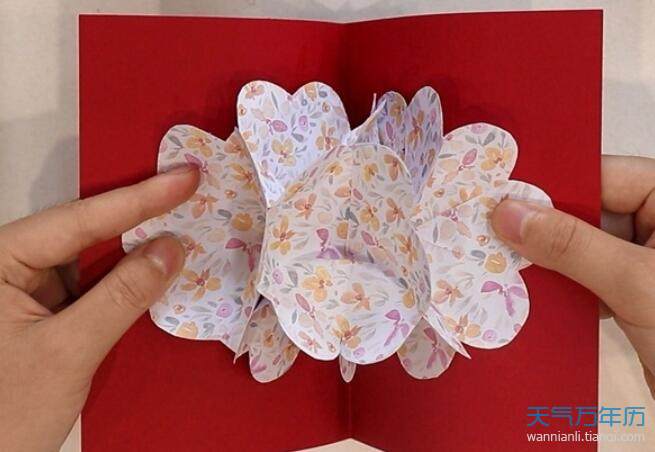 5再取一张长方形彩纸对折展开把花朵正反两面粘在纸上贺卡就做好