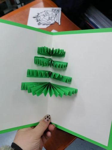 制作圣诞贺卡 具体步骤①用双面胶将米黄色的卡  纸贴在绿色的卡纸上