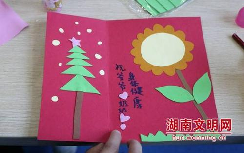 付叶馨在自制贺卡上写上对爷爷奶奶的祝福.湖南文明网 记者 余艺 摄
