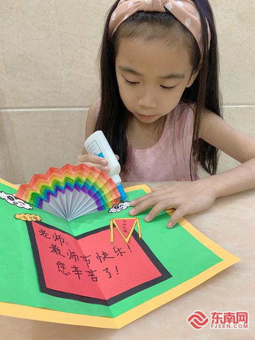 她亲手制作一张贺卡送给老师上面有彩虹蝴蝶结也有新学会的教师节