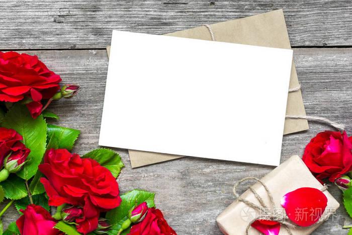 带一张空白贺卡的红玫瑰花束和带有礼品盒的信封