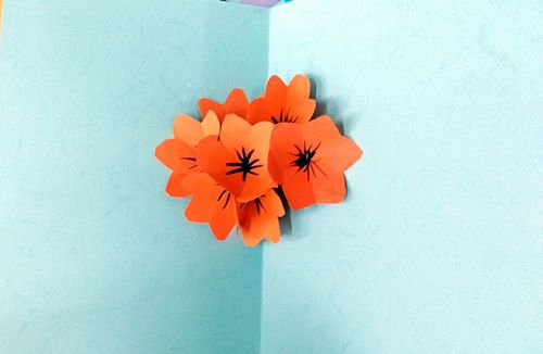 最后把小花朵黏到大卡纸中间一张立体花瓣贺卡就完成了小朋友你们