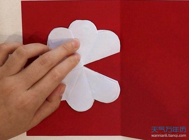 5再取一张长方形彩纸对折展开把花朵正反两面粘在纸上贺卡就做好