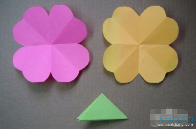 8把两朵花折成双心形绿色的三角形折纸剪出8张出来.
